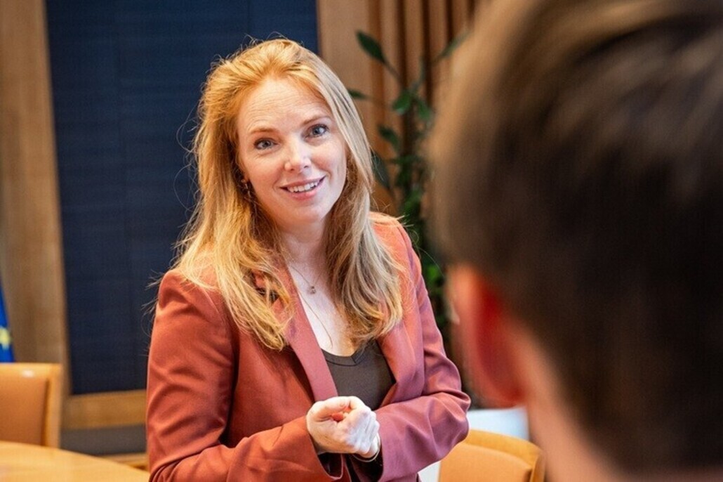 Willemijn Aerdts in gesprek met man, gezien vanaf achterhoofd