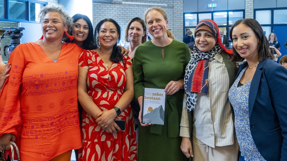 Minister Schouten met adviesdeskundigen tijdens de overhandiging van het deelrapport Commissie sociaal minimum. Het eerste rapport gaat…