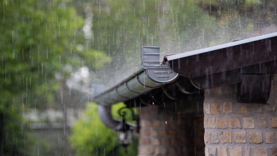 Regenwater valt neer in een dakgoot.