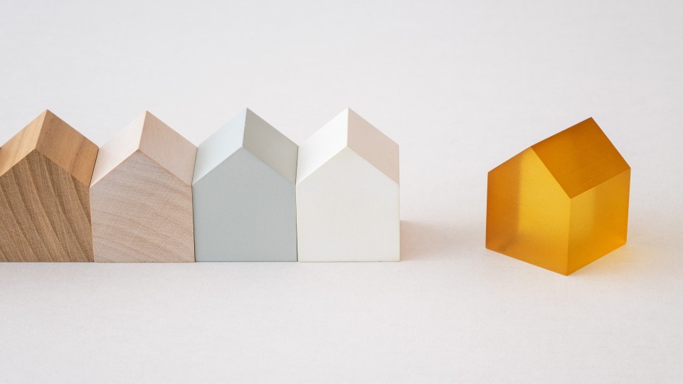 rijtje houten miniatuurhuisjes met daarnaast vrijstaand houten miniatuurhuisje