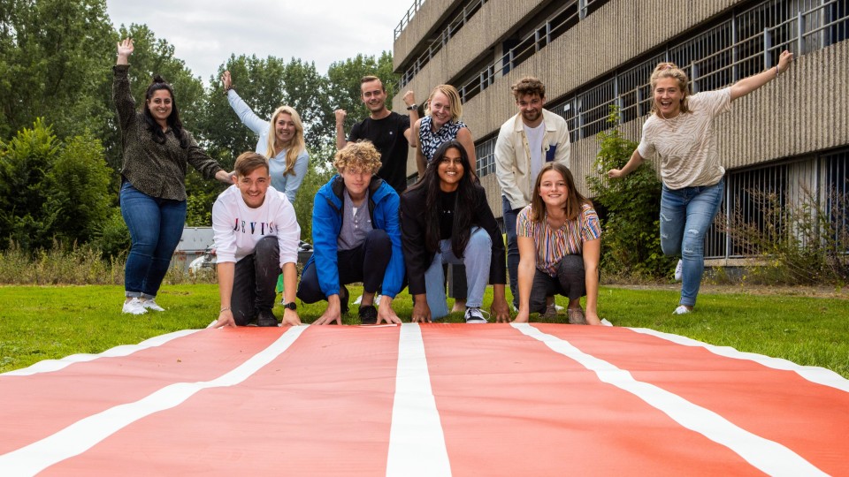 Wethouder Floor Gordon (bovenste rij, derde van rechts) met blije studenten