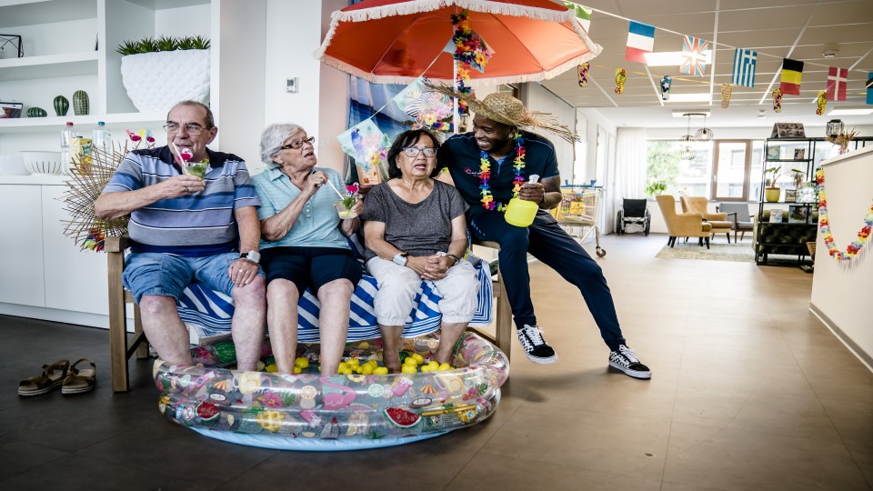 Bewoners van een verzorgingshuis in Zoetermeer zitten ter verkoeling met hun voeten in een zwembadje. Foto: Bart Maat (ANP)