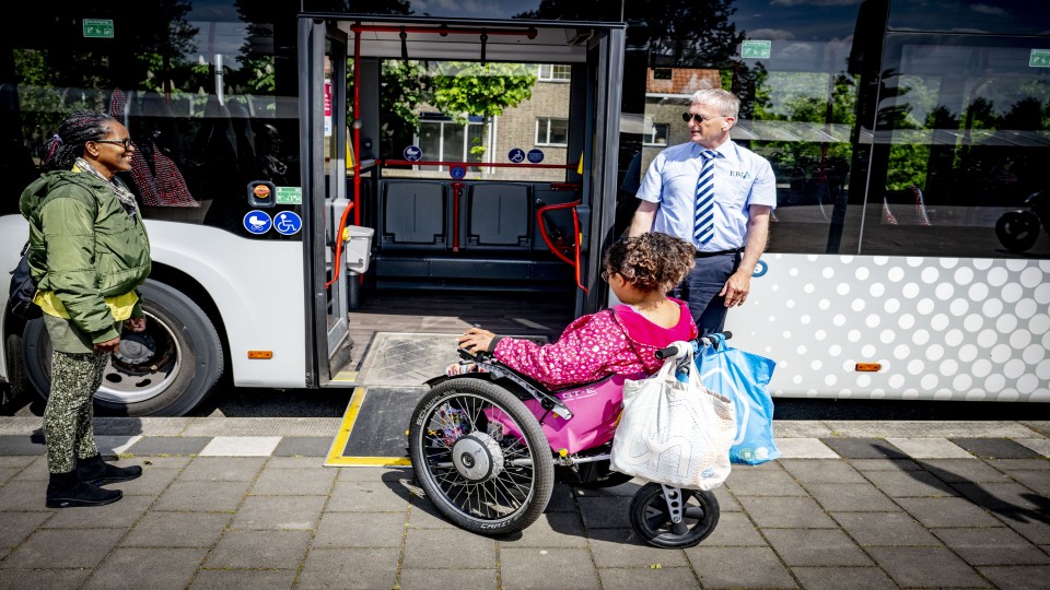 Een rolstoelgebruiker gaat met een speciale plank een bus in. Lang niet alle haltes zijn even toegankelijk. Foto: Robin Utrecht (ANP).