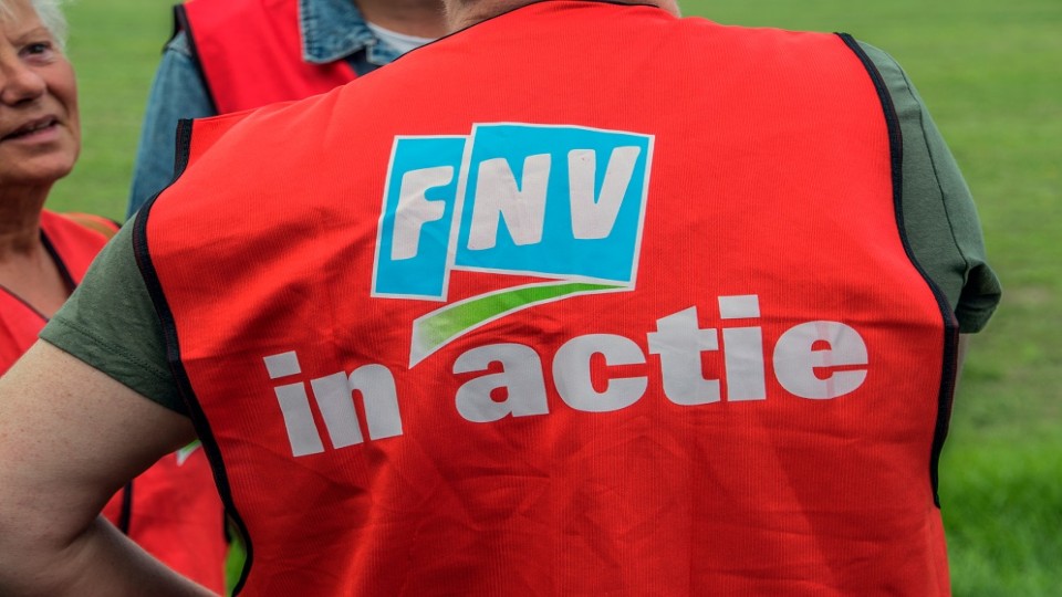 persoon met FNV-hesje, vanaf de rug gezien.