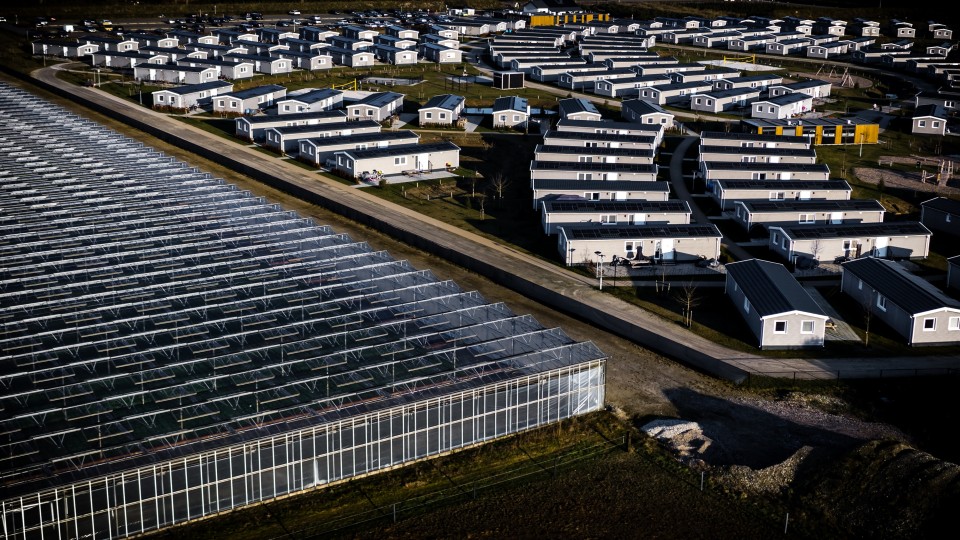 Dronefoto van tuinbouwkassen en 200 woningen in Grubbenvorst. De chalets bieden onderdak aan 800 arbeidsmigranten die vooral in de regio…