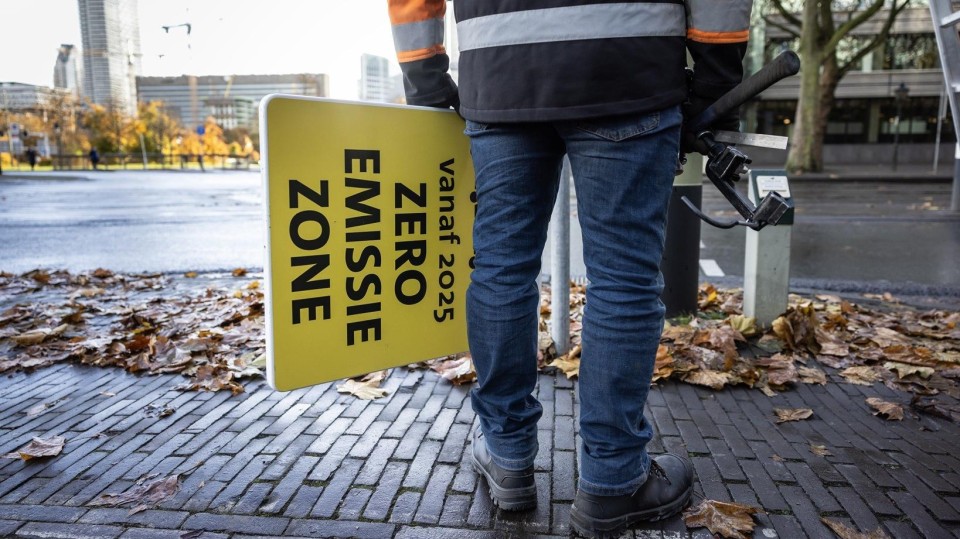 In Den Haag plaatst een gemeentewerker een bord voor een zero-emissiezone, eind vorig jaar.
