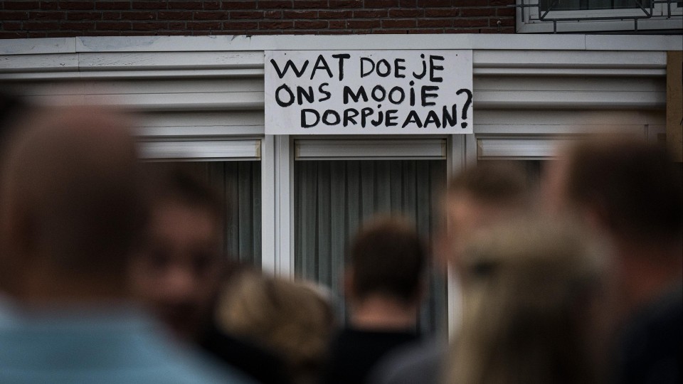 Bord met tekst: Wat doe je ons mooie dorpje aan
