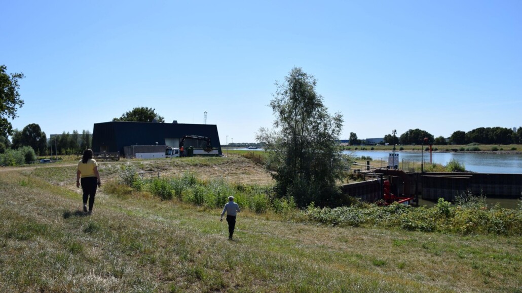 Heemraad Esther Groenenberg en woordvoerder Jelmer Krom van waterschap Rivierenland bij de pomp en gemaal