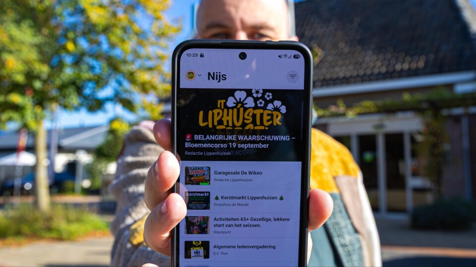 Man houdt dorpsapp van het dorp Nijs voor de camera