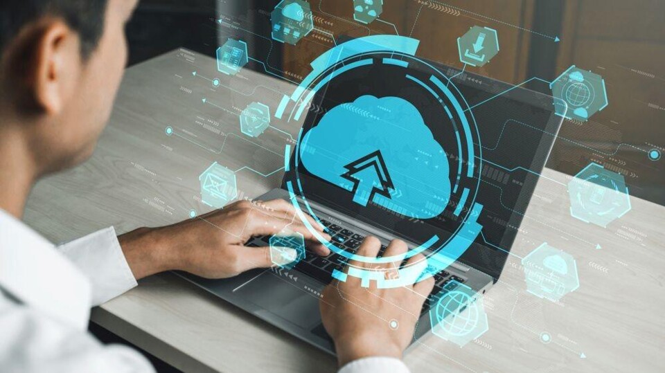 Man achter laptop, symbool van cloud met pijltje boven het scherm