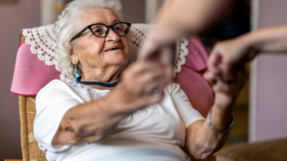 oudere vrouw wordt geholpen bij opstaan