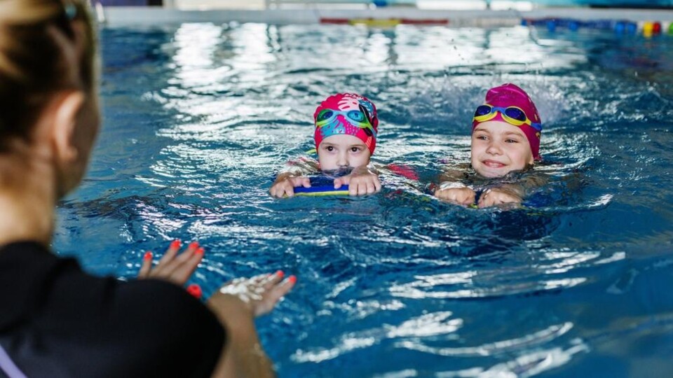 Twee kinderen zwemmen in een zwembad
