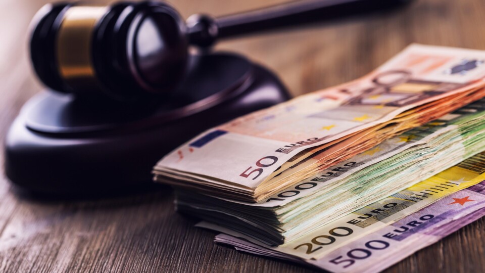 Rechtshamer met stapel bankbiljetten ernaast