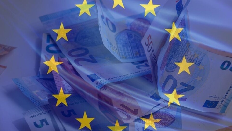Europese vlag met gele sterren over eurobankbiljetten van 5, 20, 50 en 100 euro.