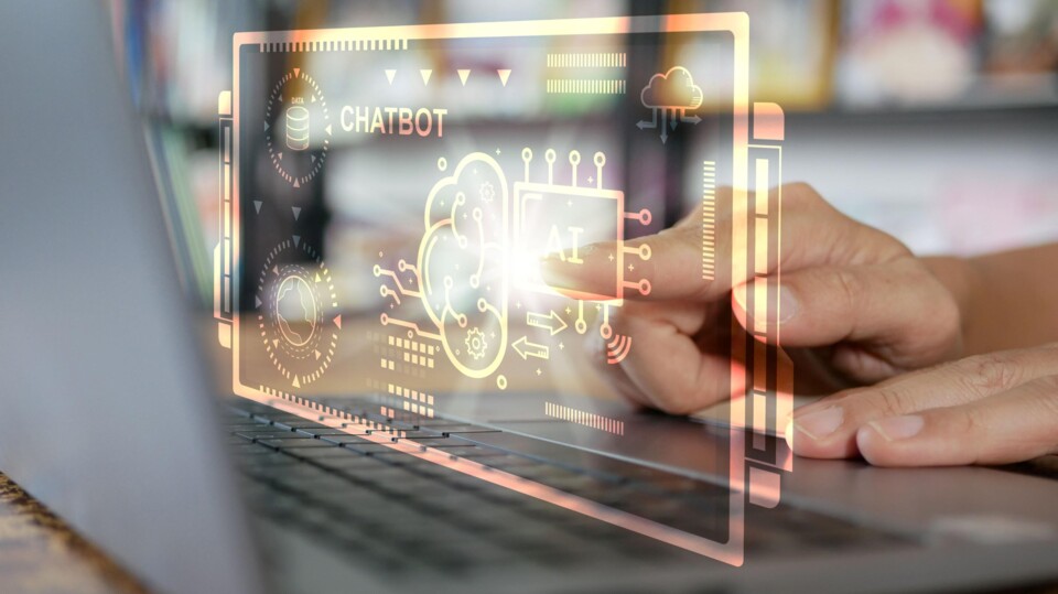 Hand raakt laptop aan met holografische chatbot AI-interface en technologie-iconen weergave