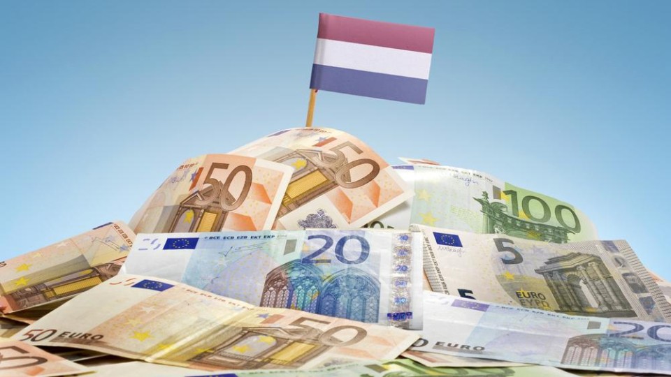 Berg Eurobiljetten met een Nederlands vlaggetje bovenop