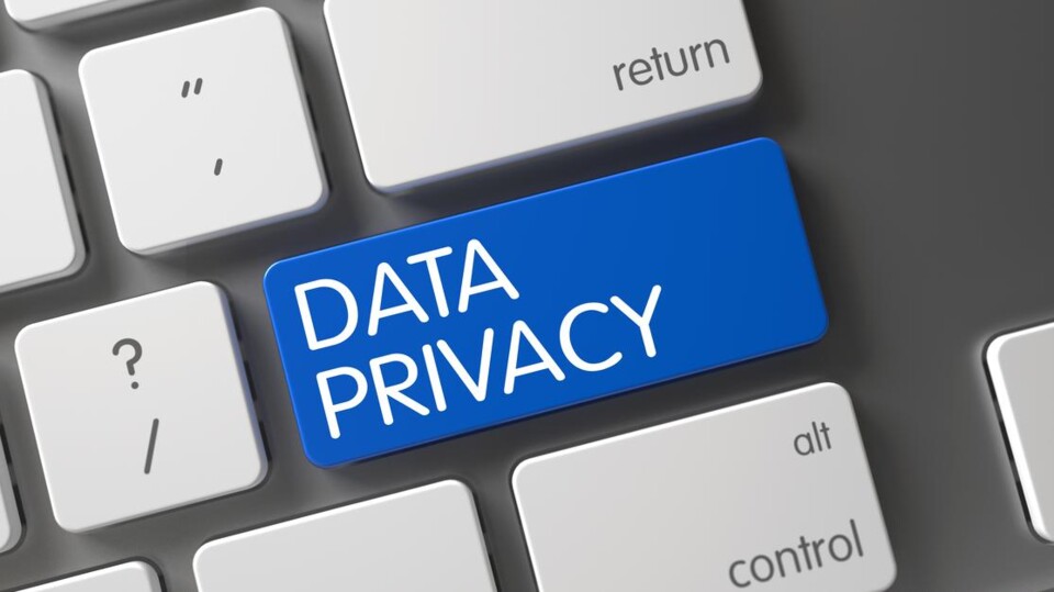 Close-up van een toetsenbord met een blauwe toets met de tekst 'DATA PRIVACY' tussen witte toetsen.