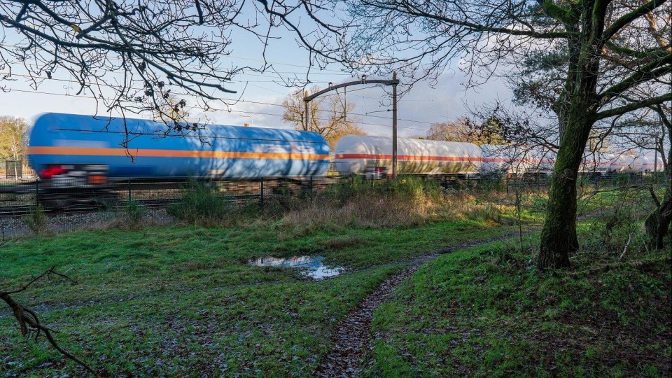 Een trein met tankwagons rijdt over het spoor van de Brabantroute tussen Breda en Tilburg ter hoogte van Rijen. 