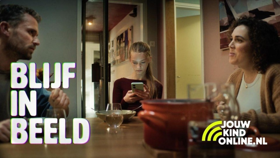 Kind op telefoon, ouders kijken naar elkaar