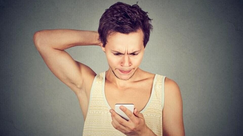 Jongen kijkt vol onbegrip naar smartphone