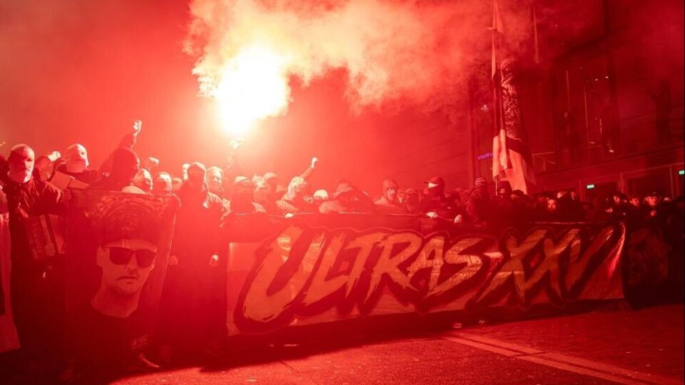 Voetbalsupporters met fakkels en een spandoek met de tekst Ultras XXV
