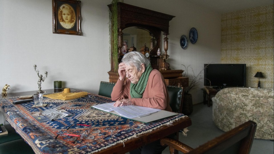 Oudere vrouw bekijkt rekeningen