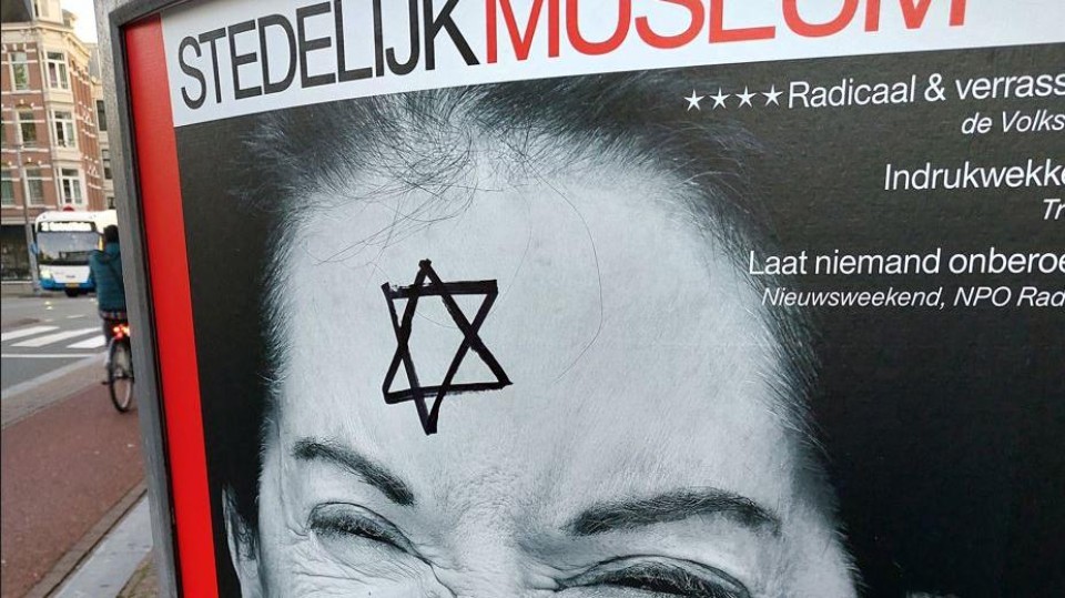 Met een viltstift heeft iemand een davidster getekend op een affiche van het stedelijk museum in Amsterdam voor een tentoonstelling van…