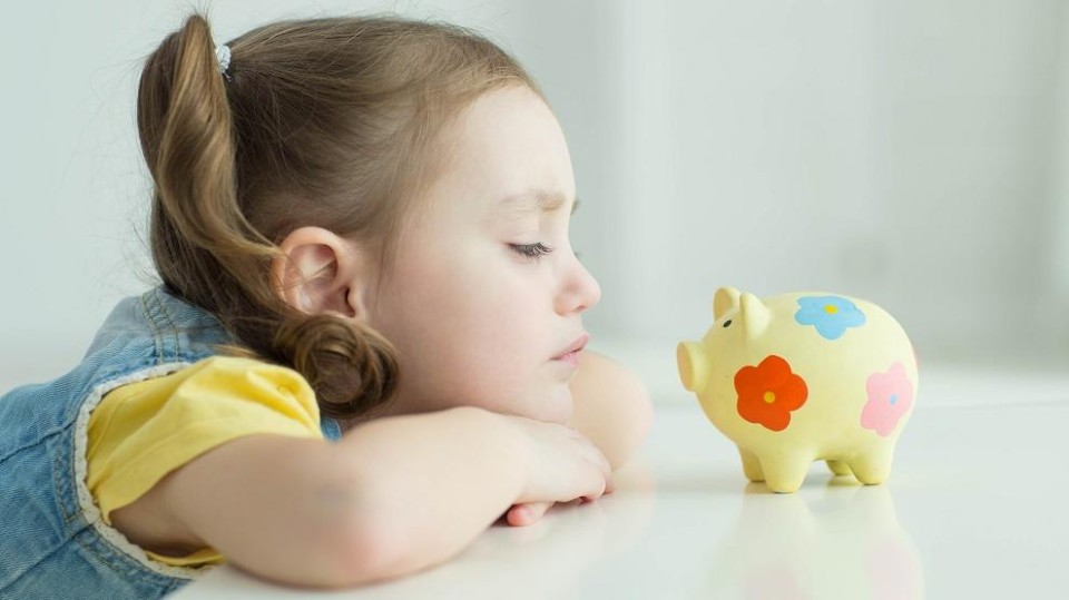 Kind kijkt naar spaarpot