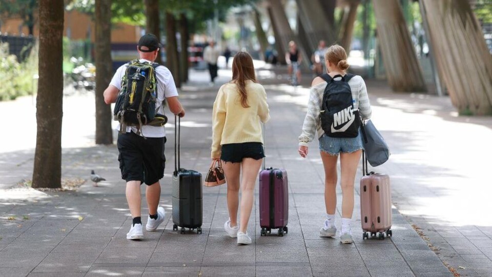 Drie toeristen met rolkoffertjes in Den Haag