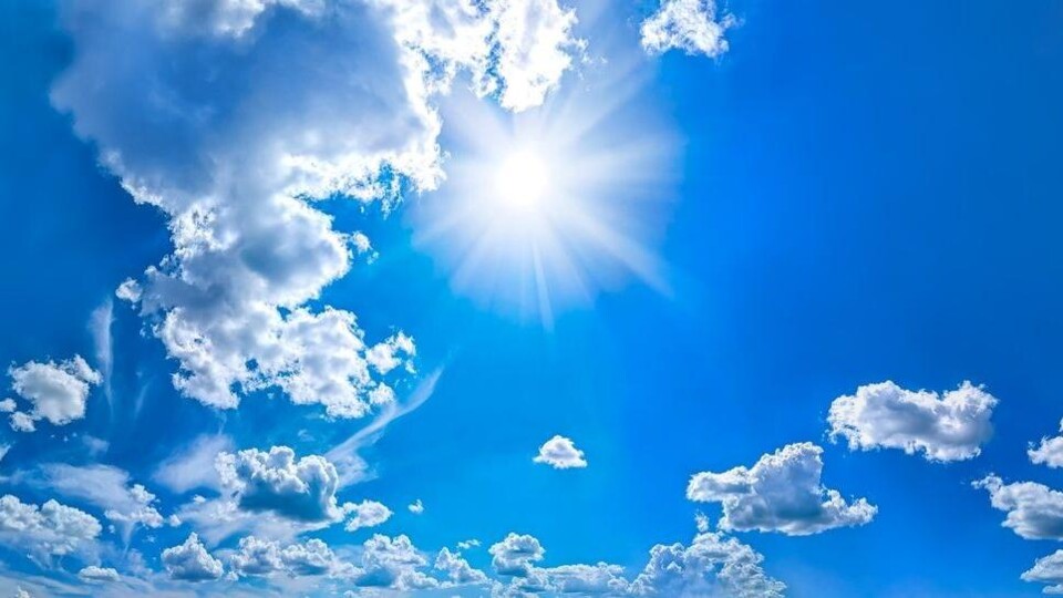 Blauwe lucht met zon en wat wolken