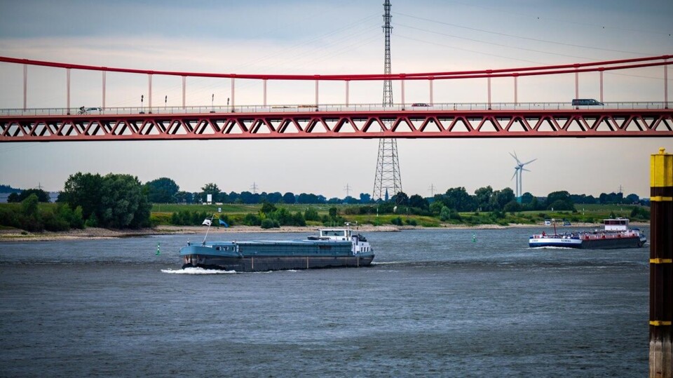 Binnenvaartschepen passeren de Rheinbrücke, net over de Duitse grens met Nederland. 