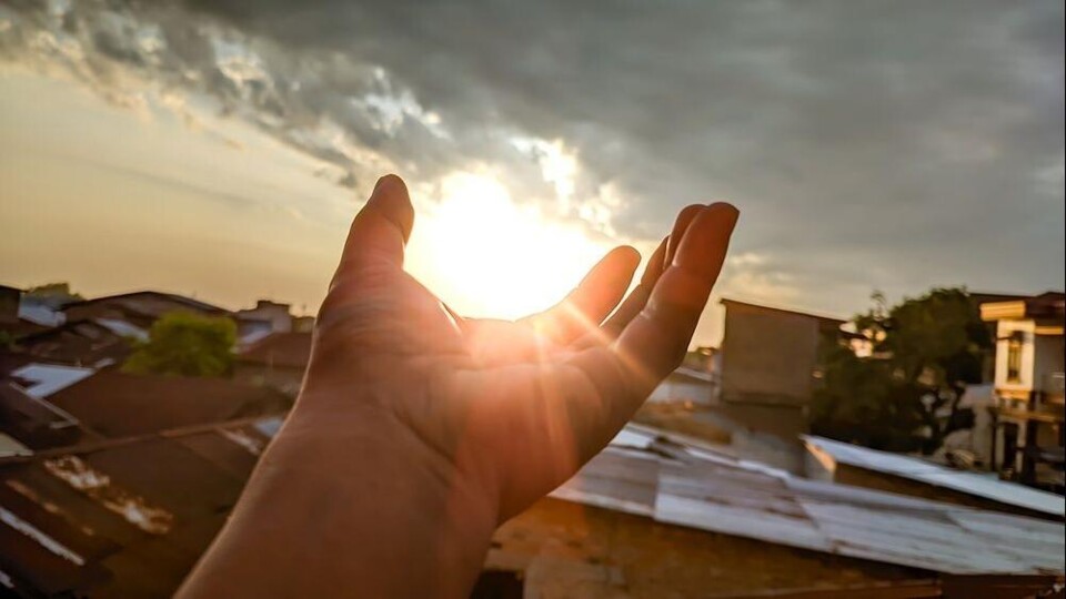 Foto van hand met zon/ wolk