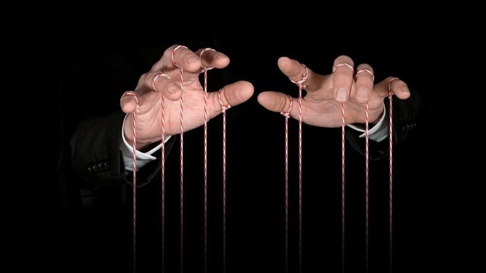 Twee handen met aan elke vinger een touwtje