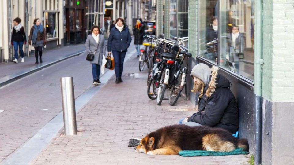 Een dakloze man met hond in Amsterdam.