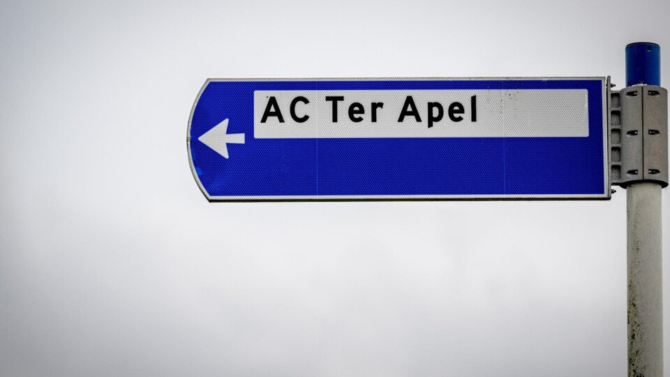 Blauw verkeersbord met pijl naar links en tekst AC Ter Apel aanmeldcentrum