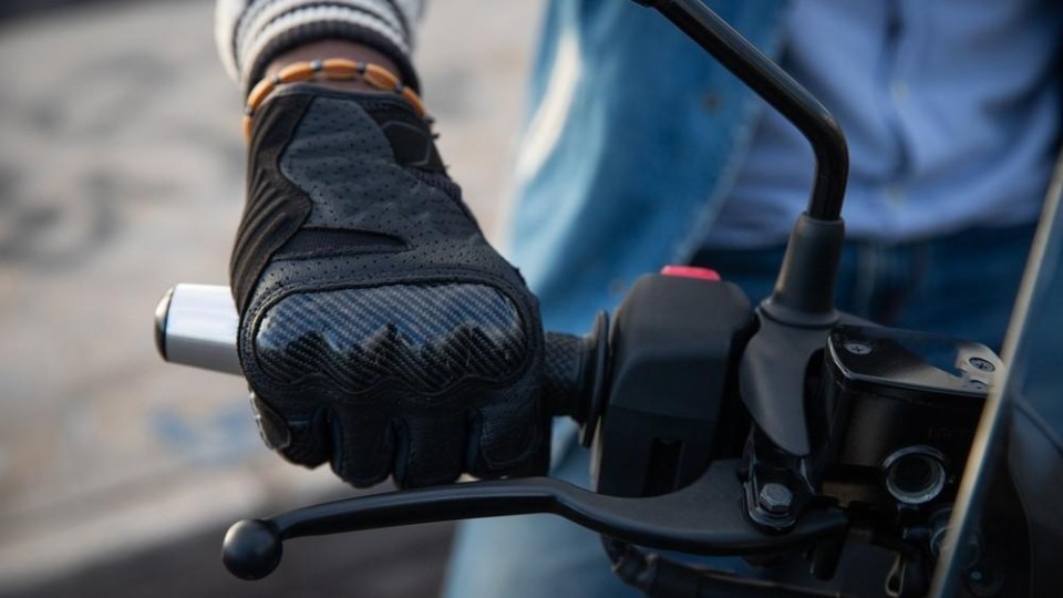 Handschoen van motorrijder op het gas