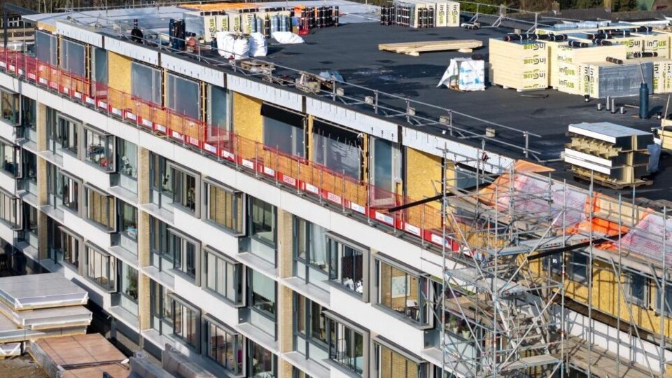 Nieuwbouwproject met meerdere verdiepingen in aanbouw, bouwmaterialen en constructiewerkzaamheden zichtbaar.