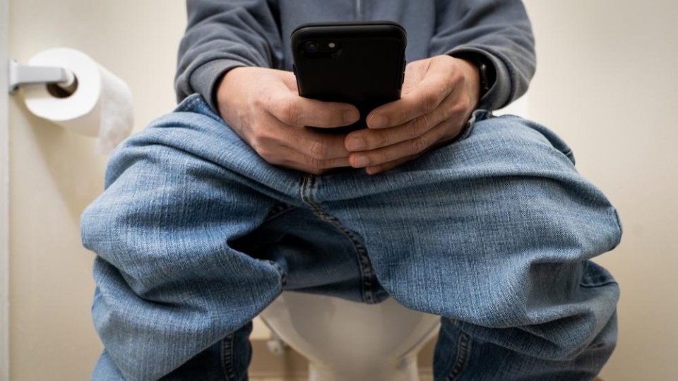 Toiletbezoek met mobiele telefoon