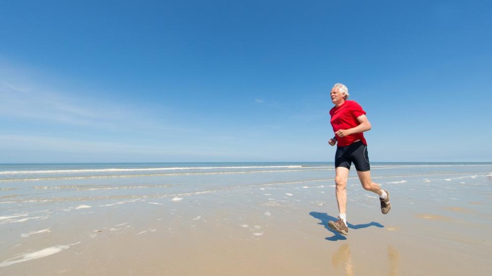 Oudere hardloper op het strand