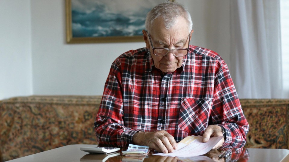 Oude man met geld en papieren