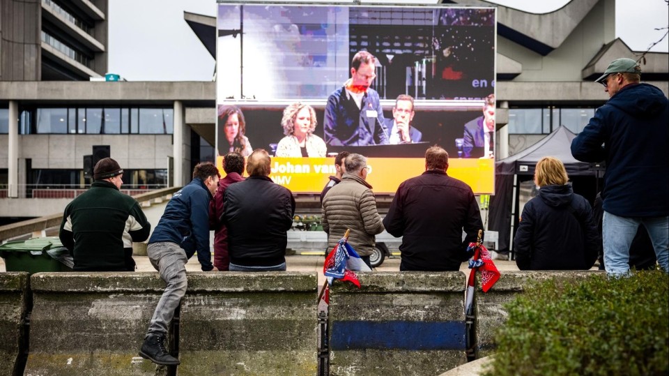 Boeren volgen de vergadering in het provinciehuis van Brabant via een scherm. 