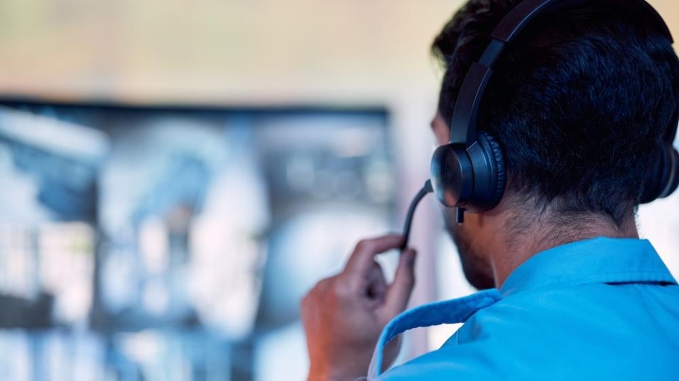 politieman achter computer spreekt in microfoon