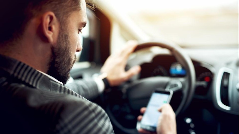 Bestuurder kijkt op telefoon