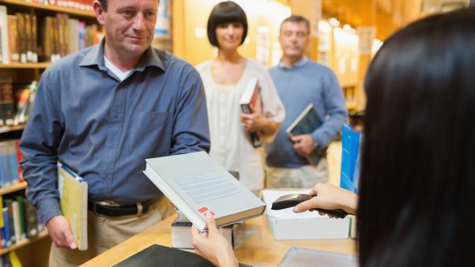 Mensen lenen boeken bij bibliotheek