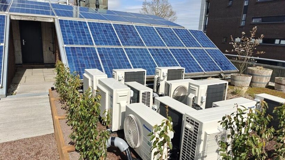 Een dakterras in Nijmegen vol zonnepanelen en airco's.