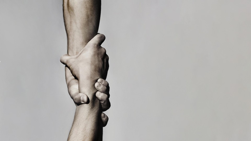 de arm en hand van de een trekt de arm en de hand van een ander omhoog