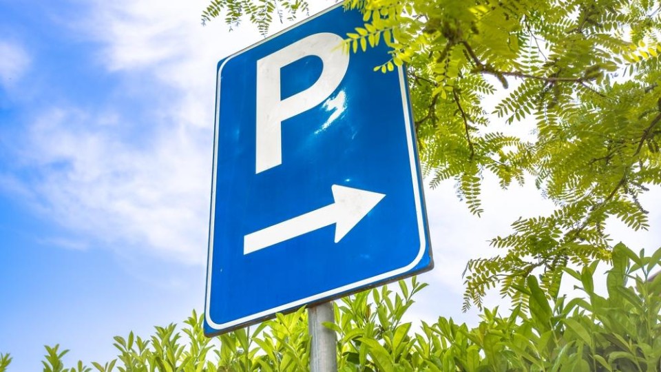 Blauw verkeersbord met witte P en een pijl