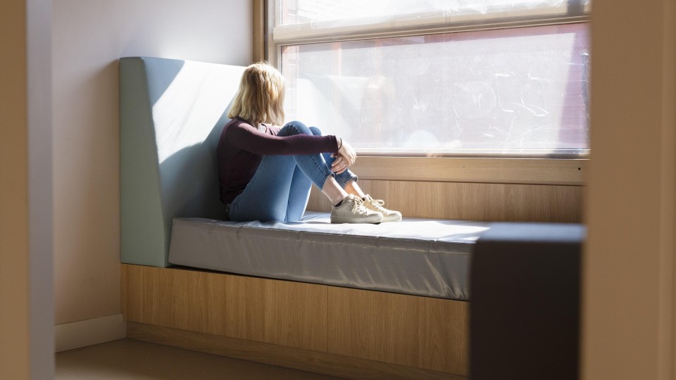 Meisje op bed kijkt uit raam