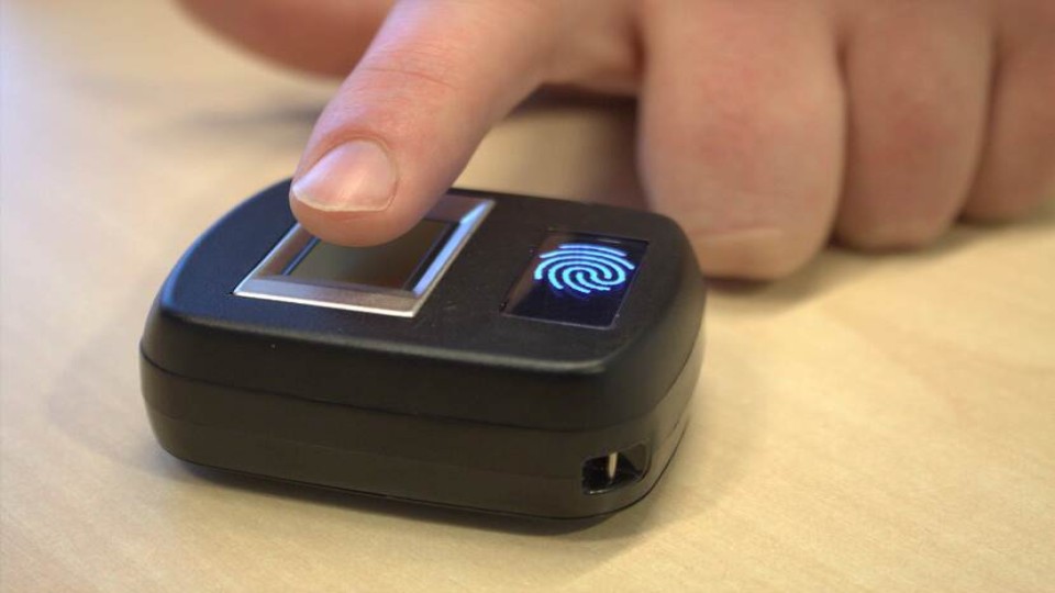 Iemand scan vingerafdruk op een Mini ID