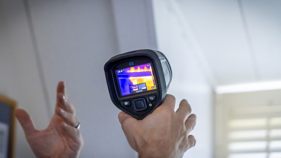 In een huis wordt een lekcheck gedaan om warmteverlies in beeld te brengen.